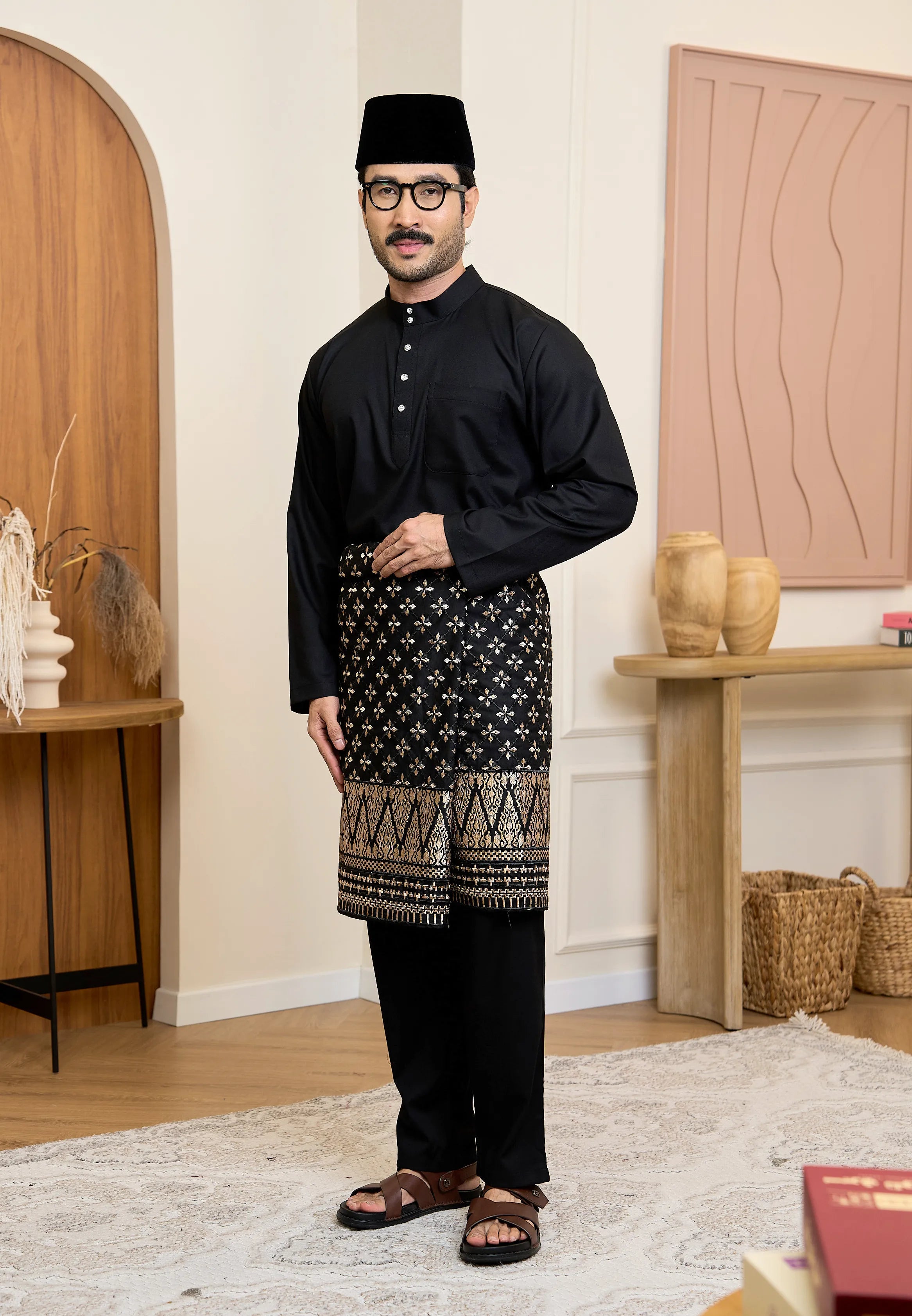 Man wearing a traditional Baju Melayu Cekak Musang in black hitam with samping and songkok