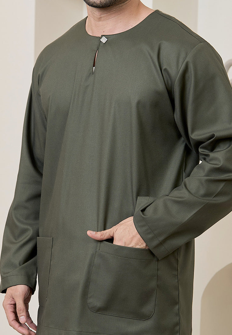 Person wearing a sage green traditional baju melayu teluk belanga long-sleeve tops with a plain background